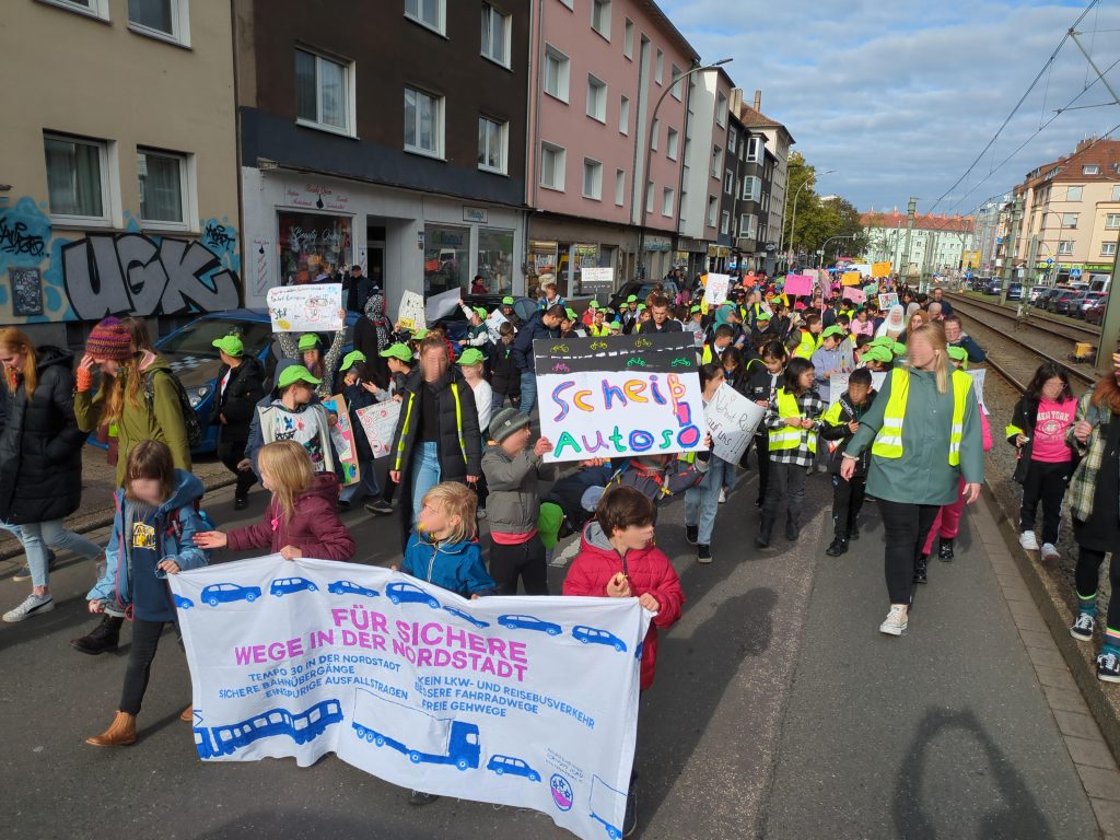 Bild eines Demonstrationszuges von Kindern die ein Transparent mit der Aufschrift "Für sichere Wege in der Nordstadt" tragen